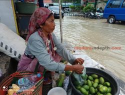 Sampang Terendam Banjir, Ibu Ini Jajakan Dagangannya di Trotoar